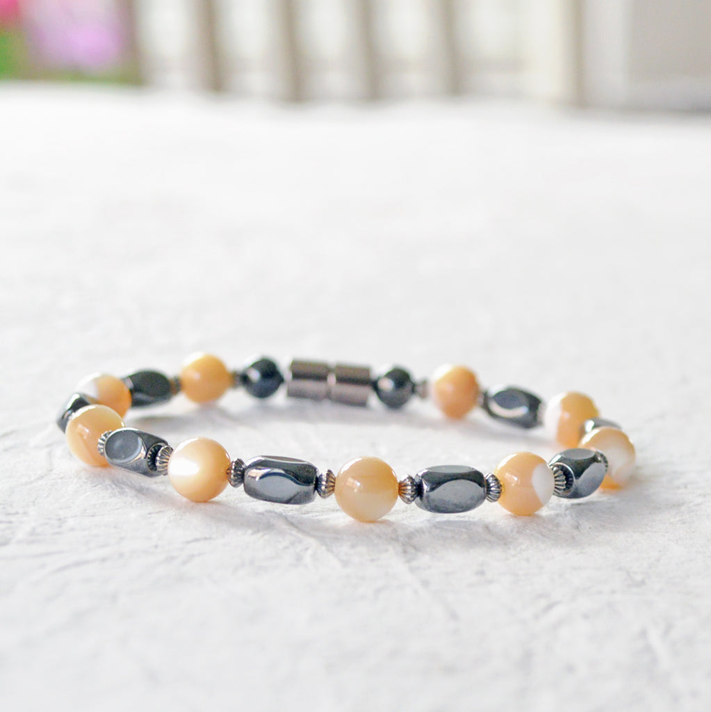 Magnetic bracelet handcrafted with black high power magnetic hematite beads, mother of pearl beads, and sterling silver spacer beads. Secured with a strong and easy-to-use magnetic clasp.