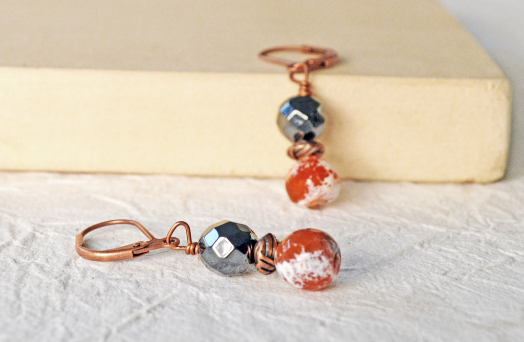 Magnetic bead earrings handcrafted with black high power magnetic hematite beads, orange fire agate gemstone, and antique copper spacer beads. The beads all hang from antique copper leverbacks.