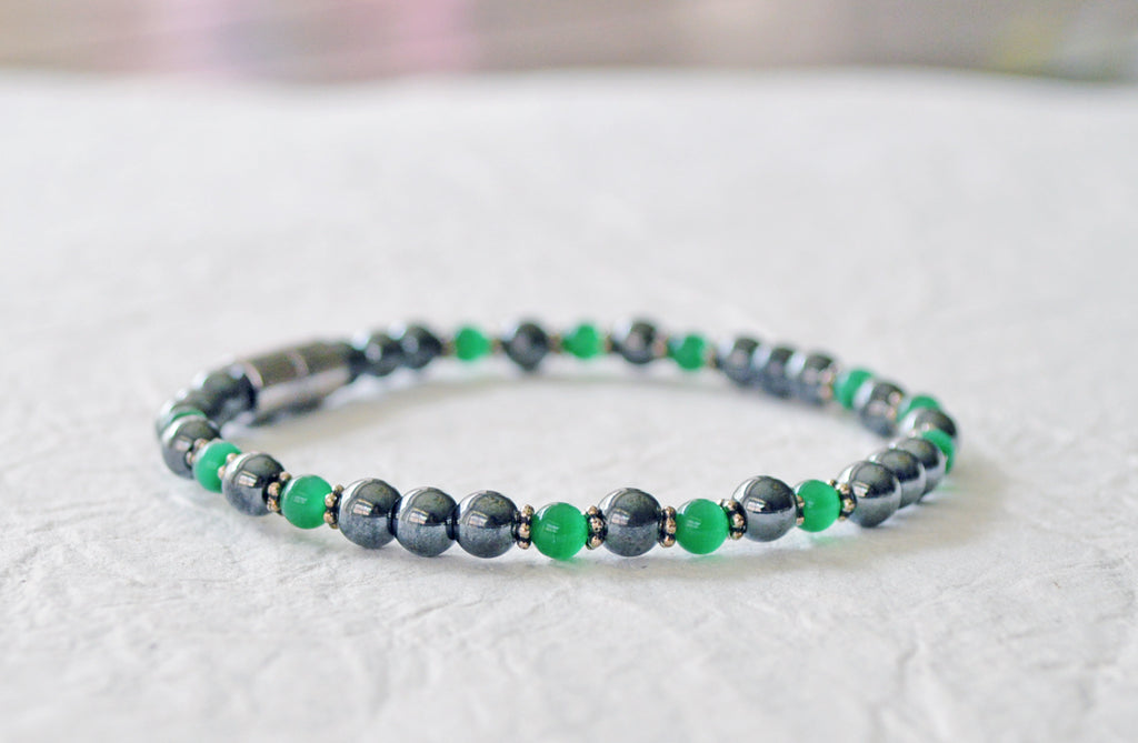 Magnetic bracelet handcrafted with black high power magnetic hematite beads and green cat's eye beads. It is secured with a strong and easy-to-use rare earth magnetic clasp.