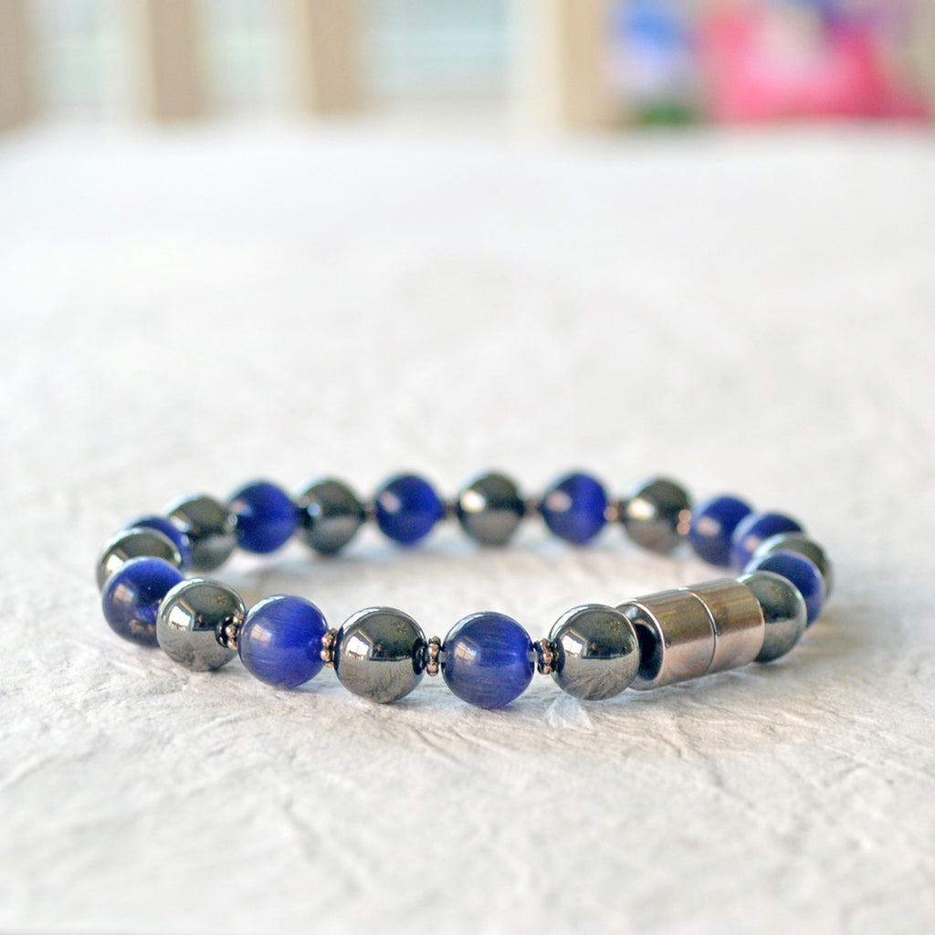 Magnetic bracelet handcrafted with alternating black magnetic hematite and blue cat's eye beads. Secured with a strong and easy-to-use magnetic clasp.