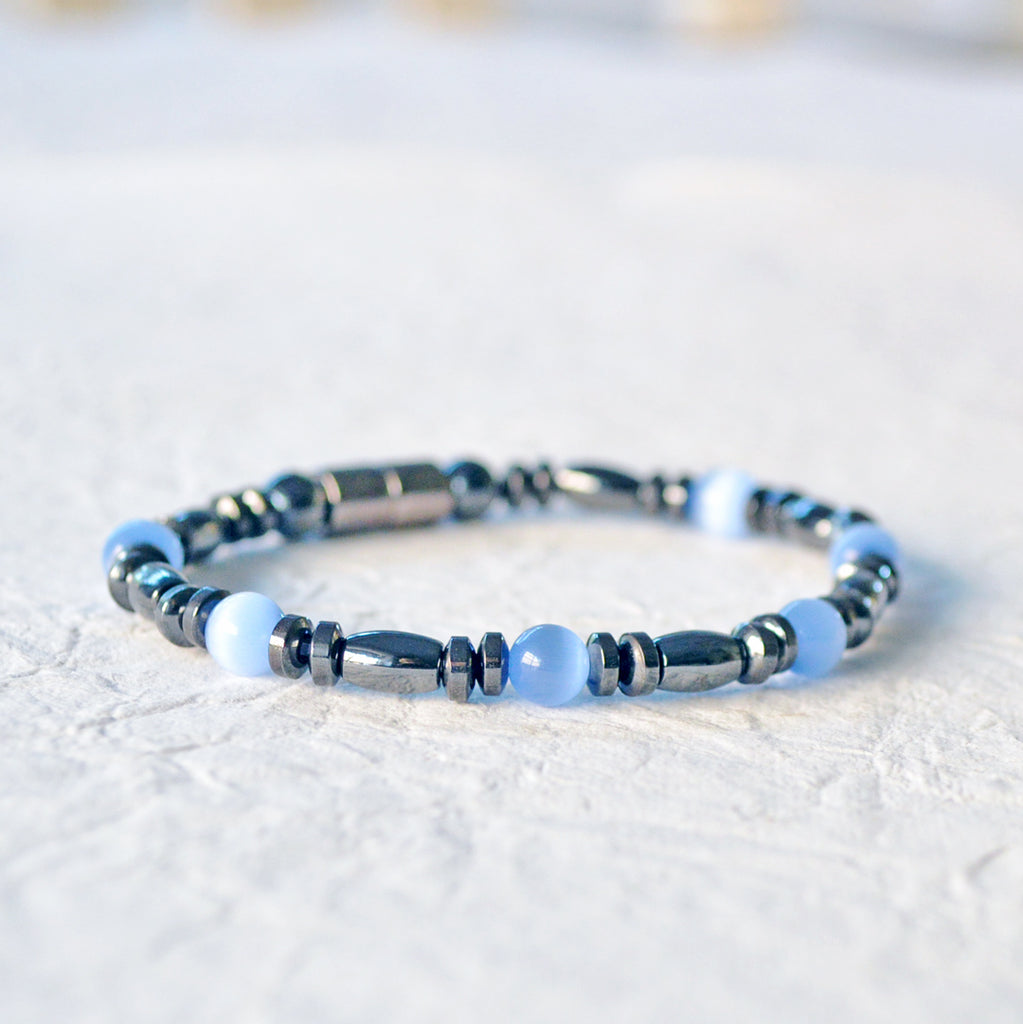 Magnetic bracelet is handcrafted with black high power magnetic hematite beads and light blue cat's eye fiber optic beads. It is secured with a strong and easy-to-use magnetic clasp.