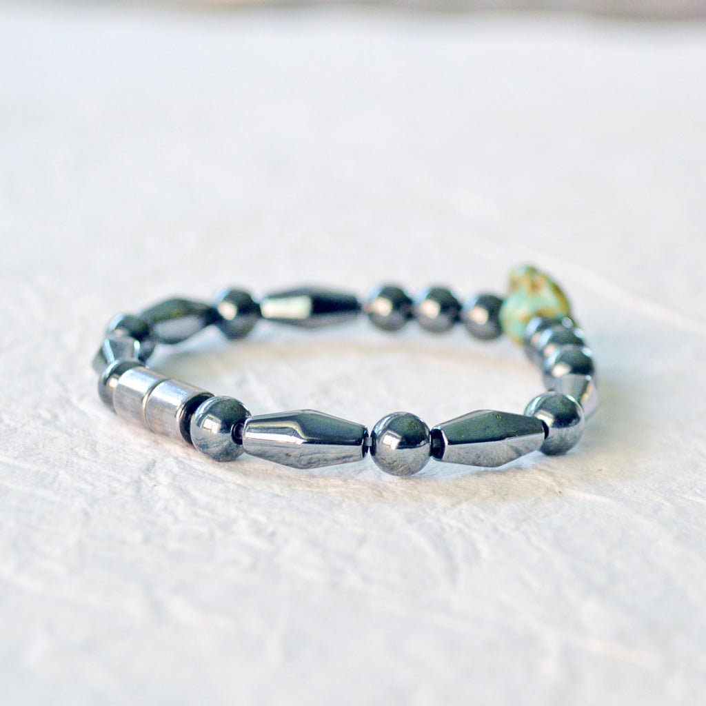 Magnetic bracelet handcrafted with black magnetic hematite beads with a single czech glass flower bead in the center. Secured with a strong rare earth magnetic clasp.