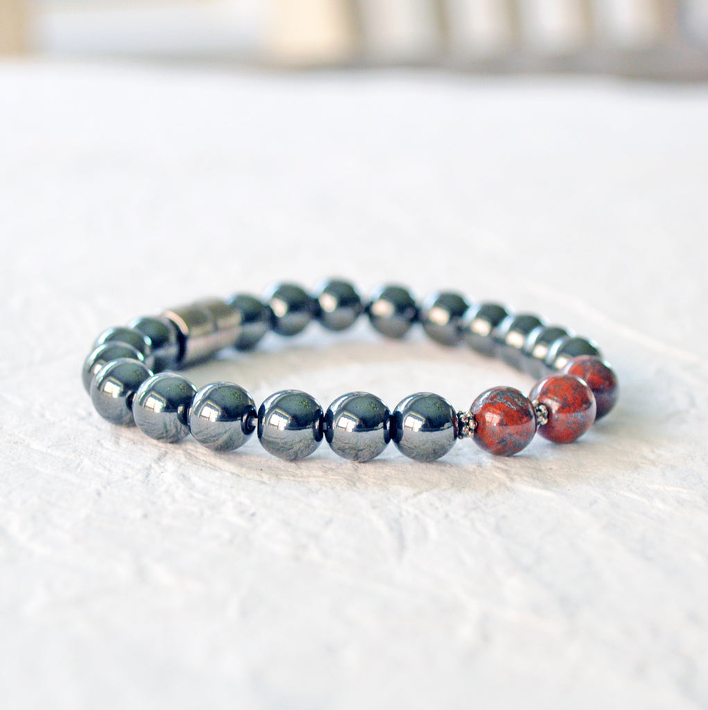 Magnetic bracelet handcrafted with black high power magnetic hematite beads. In the center are three poppy jasper gemstone beads. The bracelet is secured with a strong magnetic clasp.