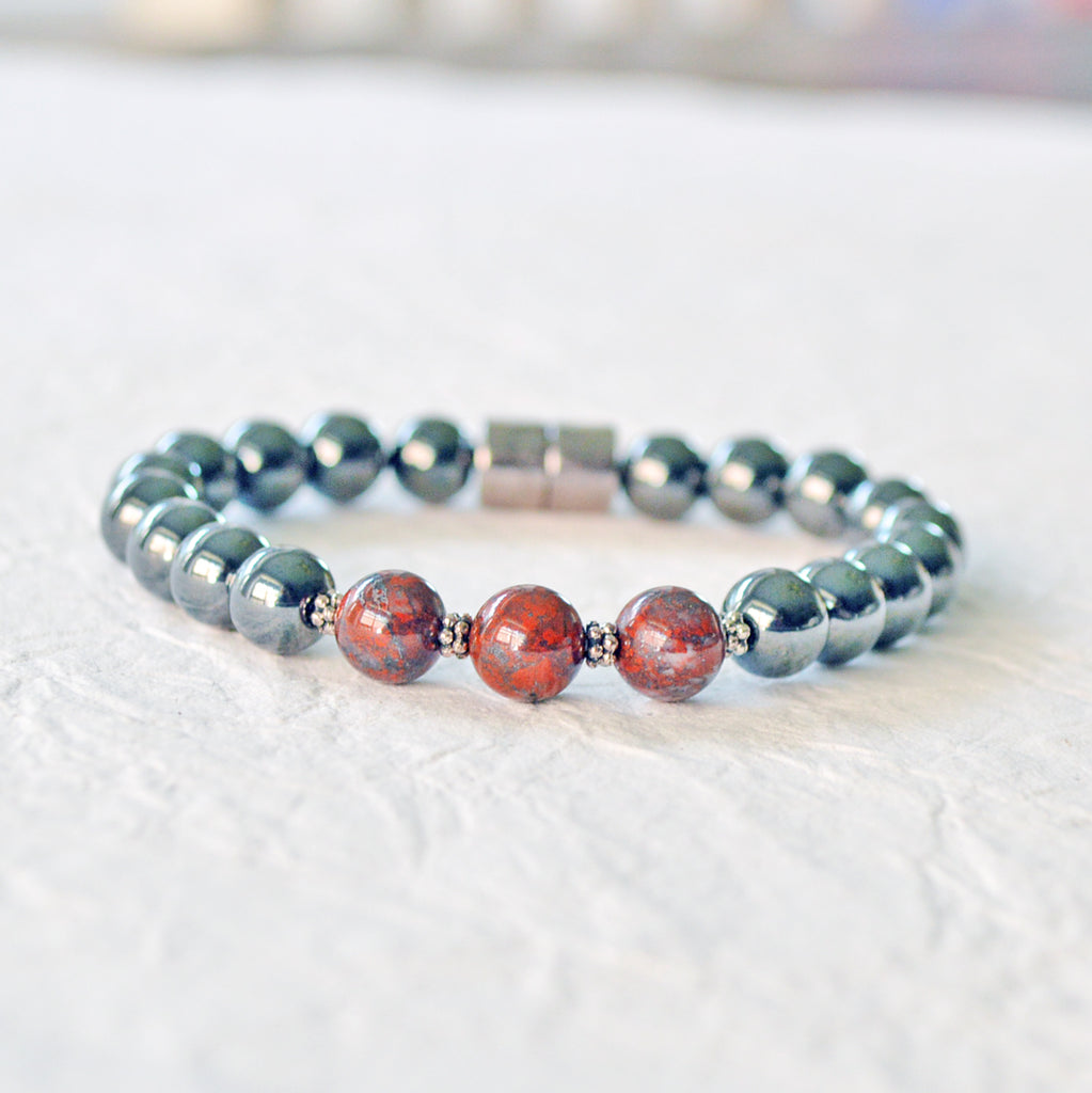 Magnetic bracelet handcrafted with black high power magnetic hematite beads. In the center are three poppy jasper gemstone beads. The bracelet is secured with a strong magnetic clasp.