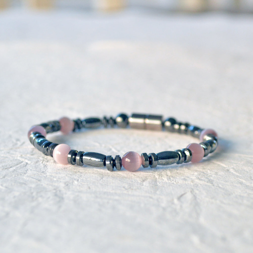 Magnetic bracelet is handcrafted with black high power magnetic hematite beads and lavender cat's eye fiber optic beads. It is secured with a strong and easy-to-use magnetic clasp.