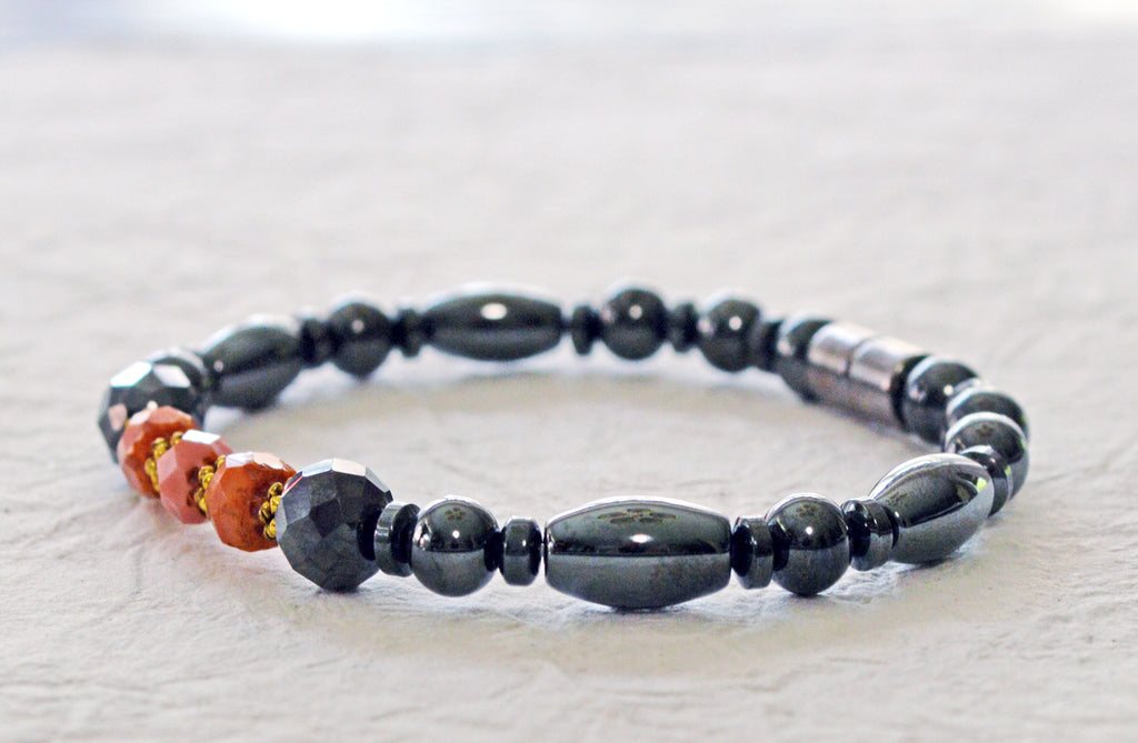 Magnetic therapy bracelet handcrafted with powerful black magnetic hematite beads with pink coral czech glass beads in the center. Secured with a strong and easy-to-use magnetic clasp.
