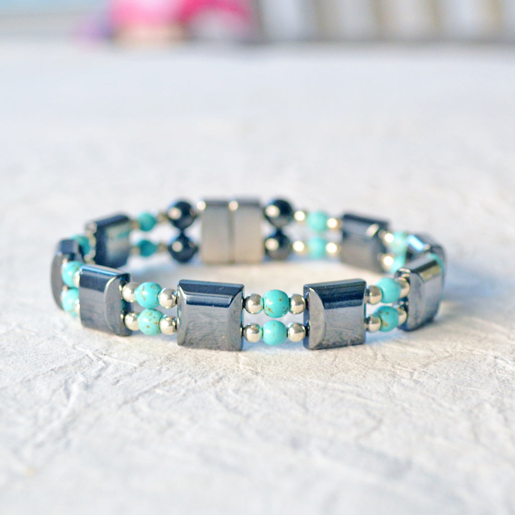 Double strand magnetic bracelet handcrafted with black magnetic hematite beads paired with turquoise magnesite beads and stainless steel silver beads. It is secured with a strong and easy-to-use magnetic clasp.