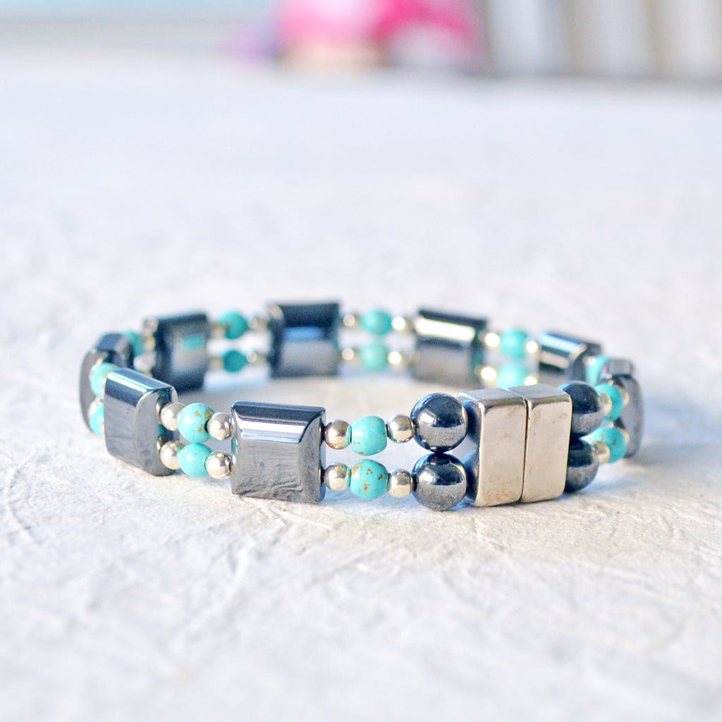 Double strand magnetic bracelet handcrafted with black magnetic hematite beads paired with turquoise magnesite beads and stainless steel silver beads. It is secured with a strong and easy-to-use magnetic clasp.
