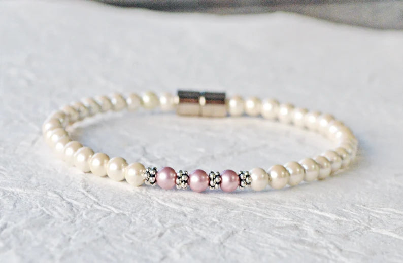 Magnetic bracelet handcrafted with pearl hematite magnetic beads. In the center are three rose Swarovski pearls surrounded by antique silver spacer beads. It is secured with a strong and easy-to-use magnetic clasp.