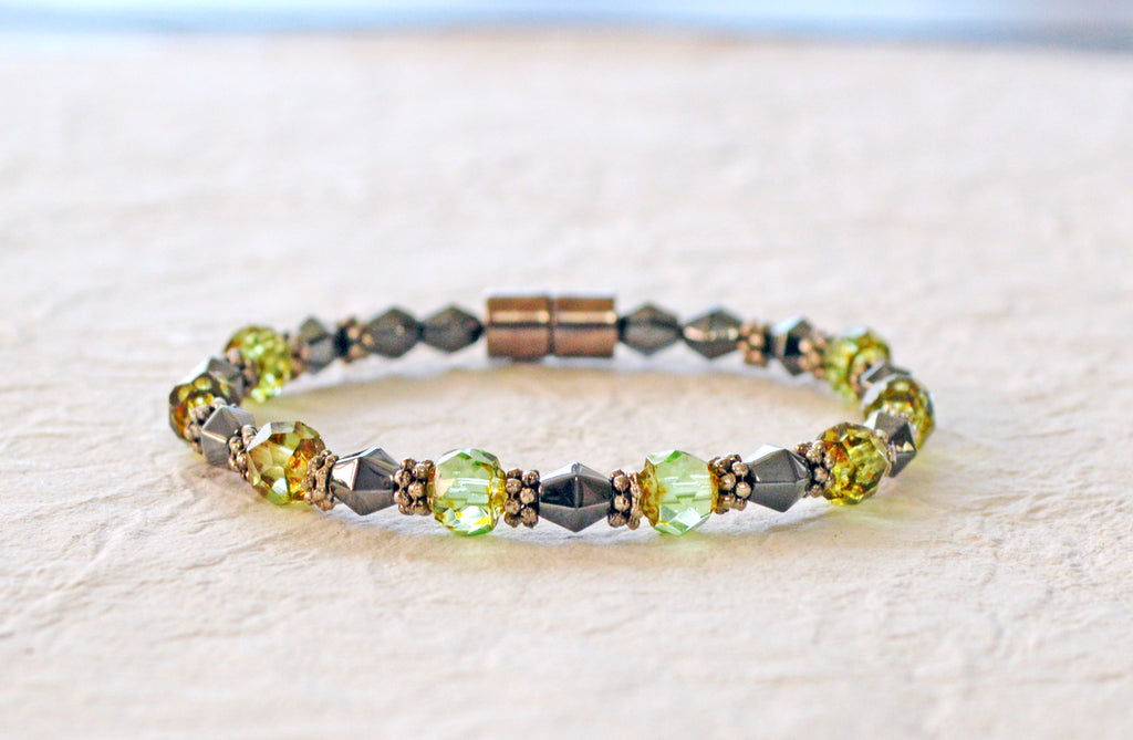 Magnetic bracelet handcrafted with black magnetic hematite beads, peridot green czech glass beads, and antique silver spacer beads. It is secured with a strong and easy-to-use magnetic clasp.