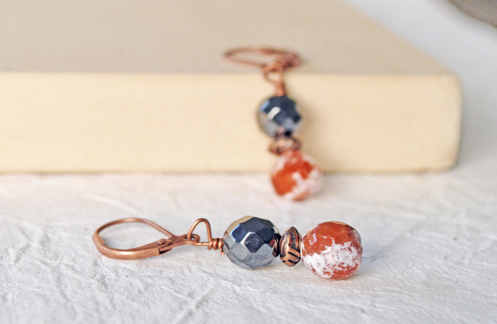 Magnetic bead earrings handcrafted with black high power magnetic hematite beads, orange fire agate gemstone, and antique copper spacer beads. The beads all hang from antique copper leverbacks.