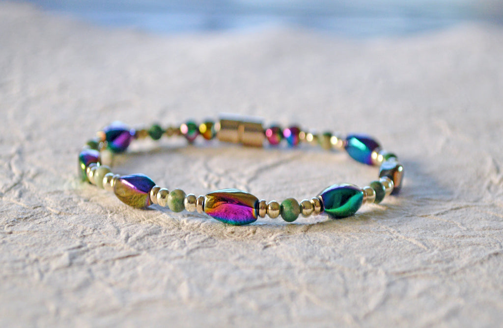 Magnetic bracelet handcrafted with iridescent rainbow hematite magnetic beads, ching hai jade gemstone beads, and antique silver spacer beads. It is secured with a strong and easy-to-use rare earth magnetic clasp.