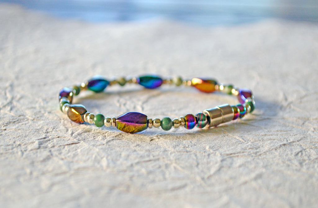 Magnetic bracelet handcrafted with iridescent rainbow hematite magnetic beads, ching hai jade gemstone beads, and antique silver spacer beads. It is secured with a strong and easy-to-use rare earth magnetic clasp.
