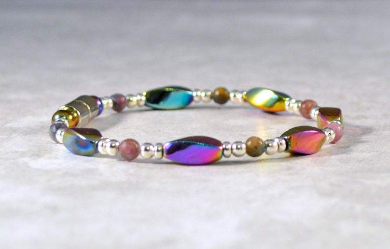 Magnetic bracelet handcrafted with iridescent rainbow hematite magnetic beads with ruby kyanite gemstone beads and antique silver spacer beads. It is secured with a strong and easy-to-use magnetic clasp.