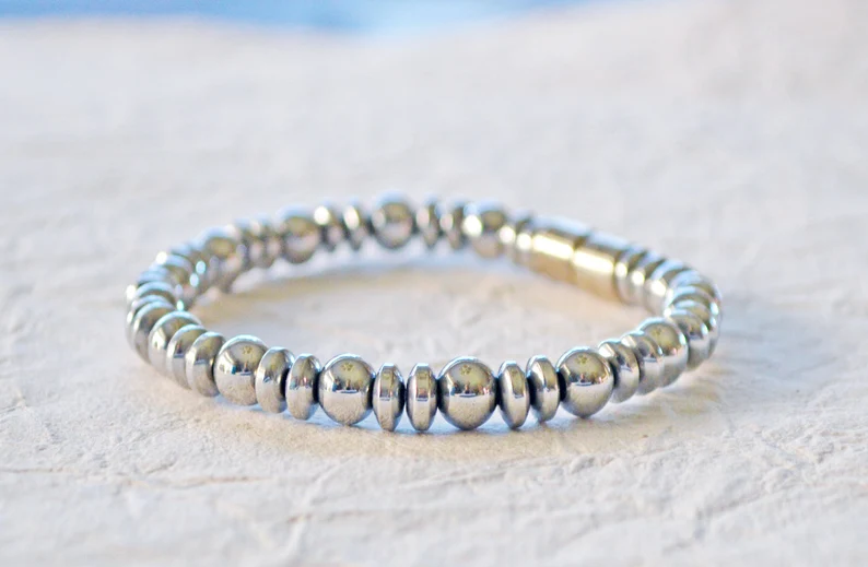 Silver magnetic bracelet handcrafted with silver metallic magnetic hematite beads. It is secured with a strong and easy-to-use magnetic clasp.