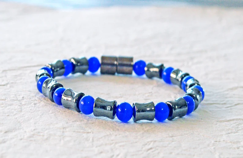 Magnetic bracelet handcrafted with alternating black high power magnetic hematite beads and blue cat's eye beads. It is secured with a strong and easy-to-use magnetic clasp.