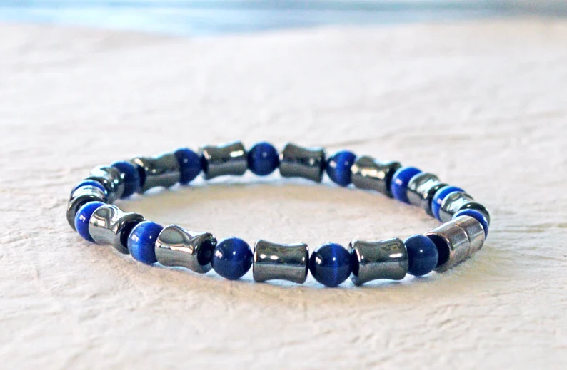 Magnetic bracelet handcrafted with alternating black high power magnetic hematite beads and dark blue cat's eye beads. It is secured with a strong and easy-to-use magnetic clasp.