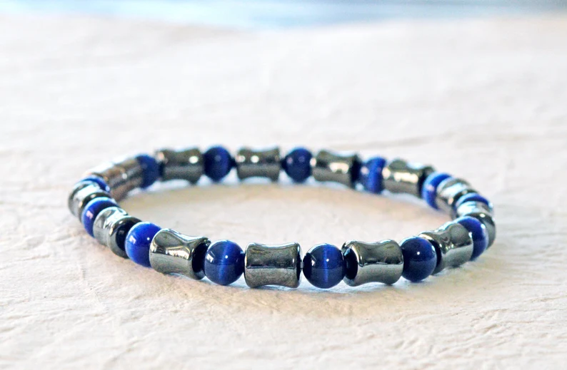 Magnetic bracelet handcrafted with alternating black high power magnetic hematite beads and dark blue cat's eye beads. It is secured with a strong and easy-to-use magnetic clasp.