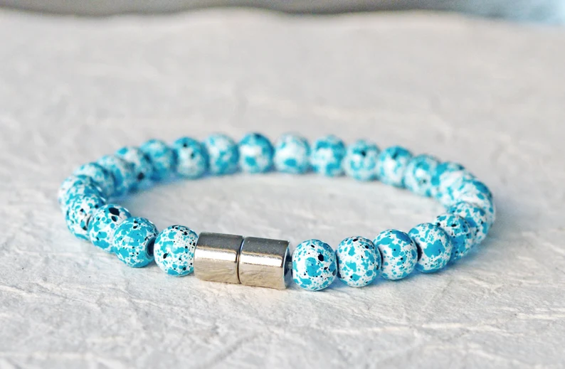 Magnetic bracelet handcrafted with magnetic hematite beads that are speckled in turquoise, white, and a bit of black. It is secured with a strong and easy-to-use magnetic clasp.